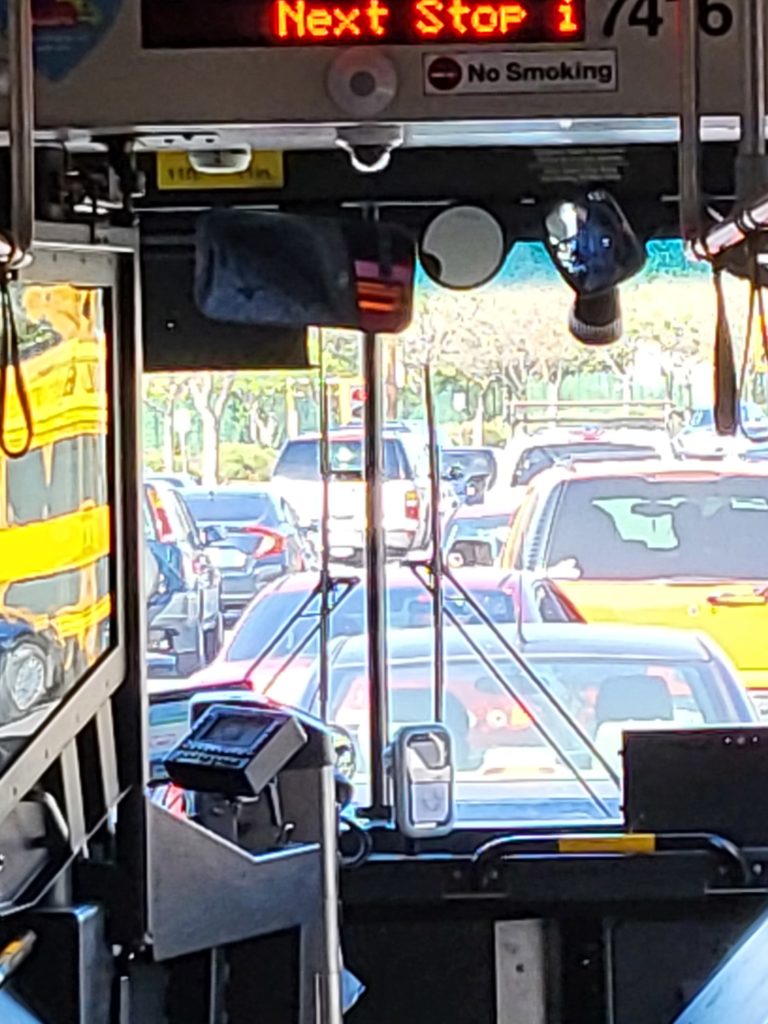 Interior of a VTA 568 Rapid bus facing the front window. Lots of auto traffic seen out of the front window.