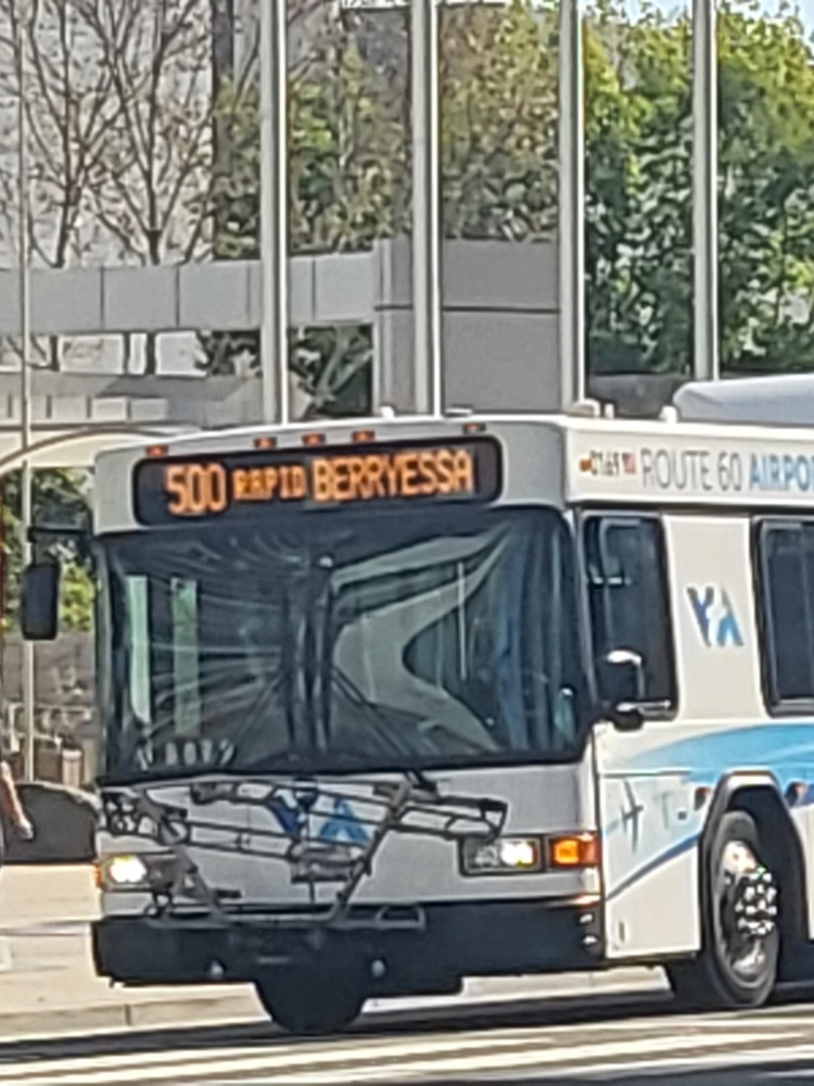 Front of VTA 40-foot Gillig low floor bus 0169, branded as "ROUTE 60 AIRPORT FLYER" serving the 500 Rapid to Berryessa BART station. Photo taken across from San Jose City Hall on E. Santa Clara St.