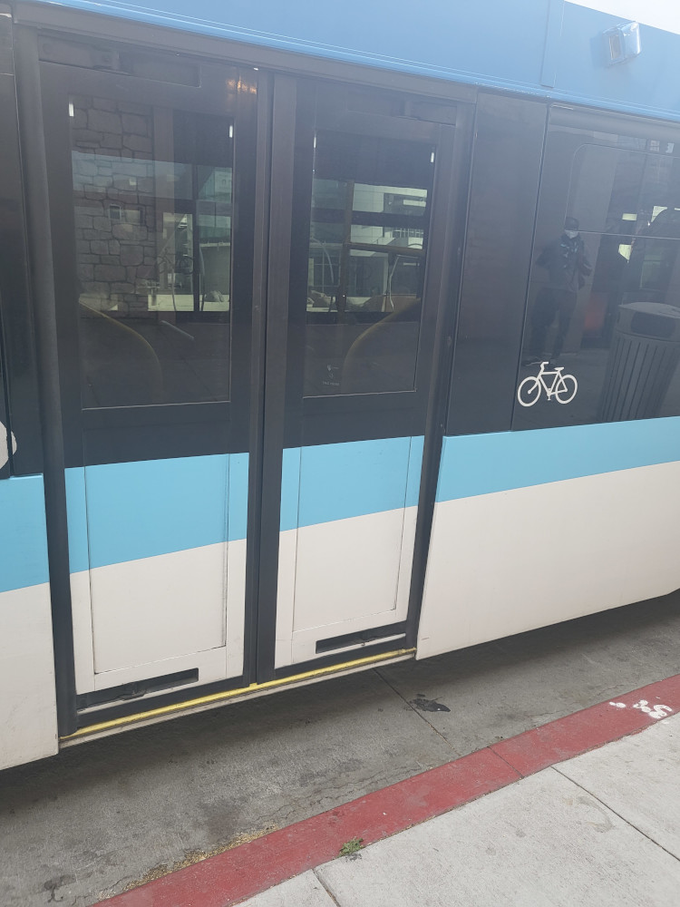 Rear door of VTA 60-foot articulated bus made by New Flyer. Bicycle picture to the right of the door. Those with a bicycle can use this door to board with their bicycle and pay fare via Clipper Card reader on the right, after entering bus.