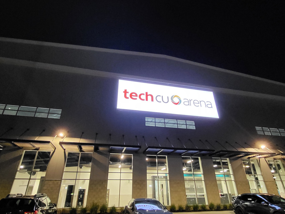 Front of TechCU hockey Arena on 10th off Alma St. in San Jose. Photo taken at night with "techCU Arena" neon sign lit on.